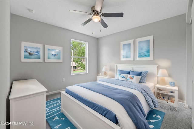 bedroom with ceiling fan, a textured ceiling, and carpet floors