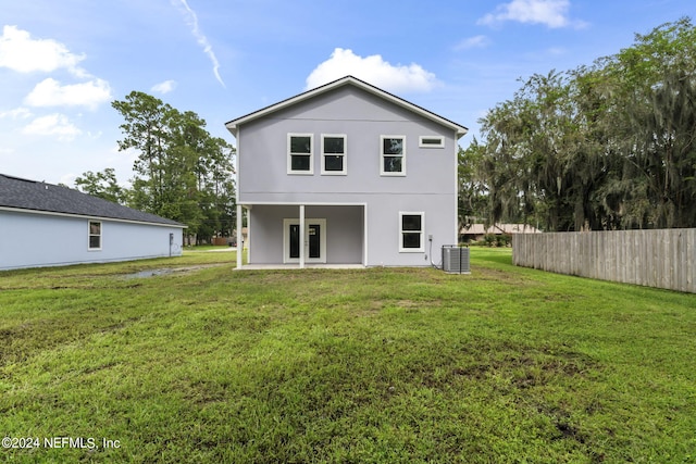 back of property with a yard and central air condition unit