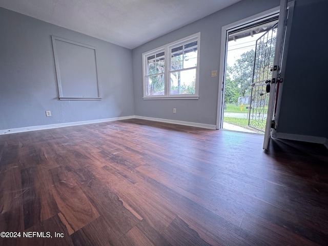 unfurnished room with dark wood-type flooring