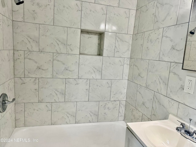 bathroom with tiled shower / bath combo and vanity