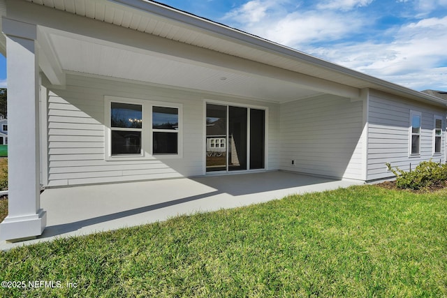 rear view of property with a lawn and a patio