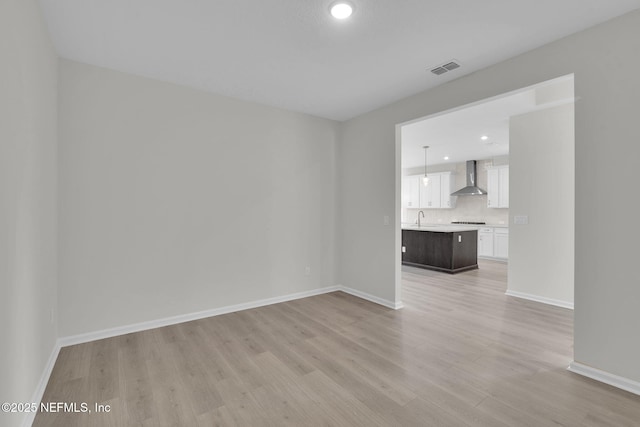 empty room featuring sink and light hardwood / wood-style flooring