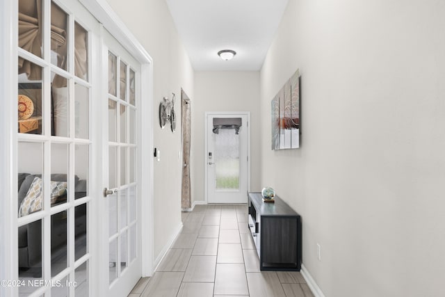 corridor featuring a textured ceiling and light tile patterned floors