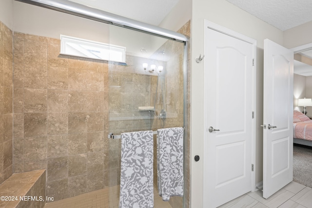 bathroom featuring a textured ceiling and a shower with door