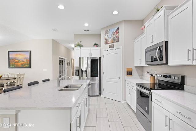 kitchen with an island with sink, sink, stainless steel appliances, and white cabinets