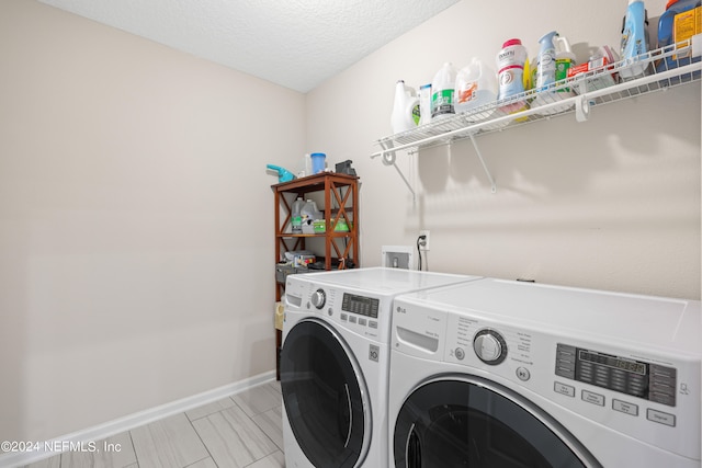 washroom featuring a textured ceiling and washing machine and clothes dryer