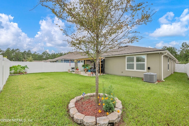 rear view of house with cooling unit, a patio area, and a yard