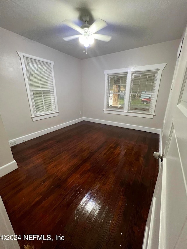 unfurnished room featuring ceiling fan and dark hardwood / wood-style floors