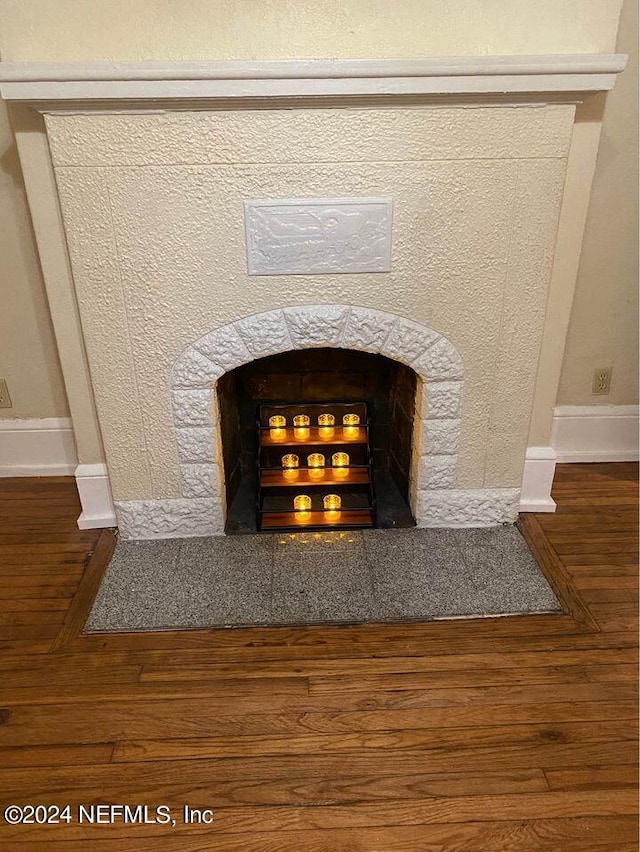 details featuring wood-type flooring and a tile fireplace