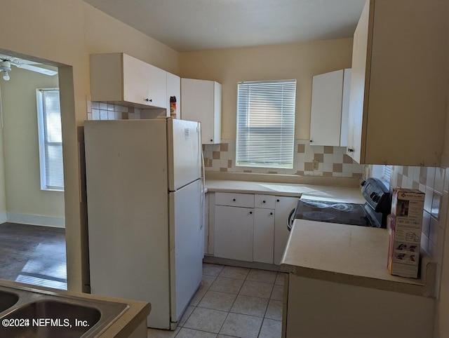 kitchen featuring ceiling fan, range with electric stovetop, white refrigerator, and white cabinetry