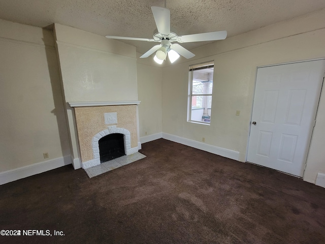 unfurnished living room featuring a textured ceiling, dark carpet, ceiling fan, and a fireplace