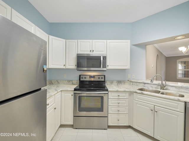 kitchen with white cabinets, light tile patterned floors, appliances with stainless steel finishes, light stone countertops, and sink