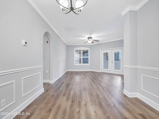 interior space featuring ceiling fan with notable chandelier, ornamental molding, and hardwood / wood-style flooring