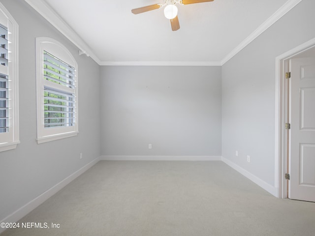 carpeted spare room with ceiling fan and ornamental molding