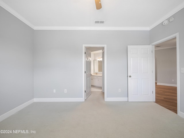 unfurnished bedroom with crown molding, ceiling fan, light colored carpet, and connected bathroom