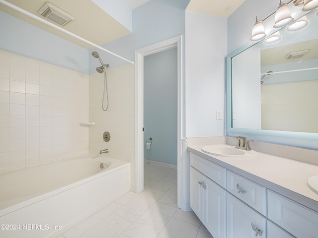 bathroom featuring tiled shower / bath combo and vanity