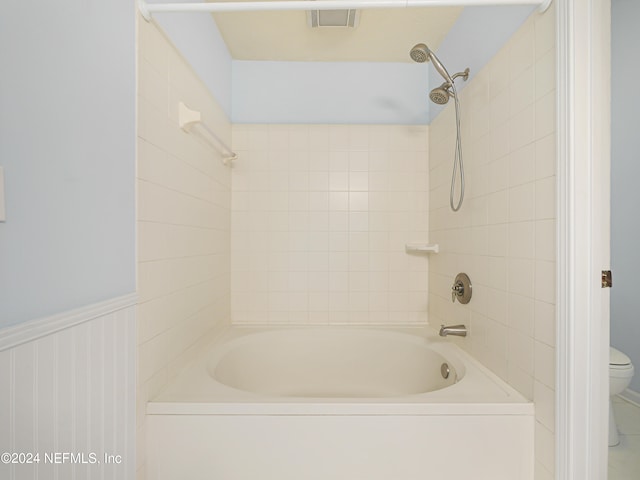 bathroom featuring tiled shower / bath and toilet