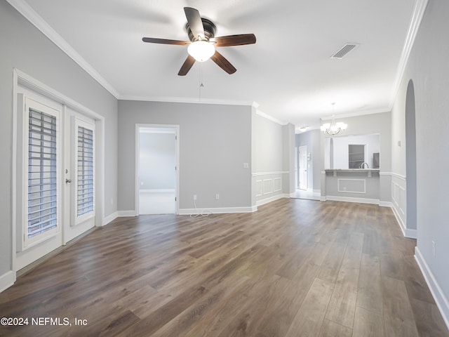 unfurnished living room featuring ceiling fan with notable chandelier, crown molding, and dark hardwood / wood-style flooring