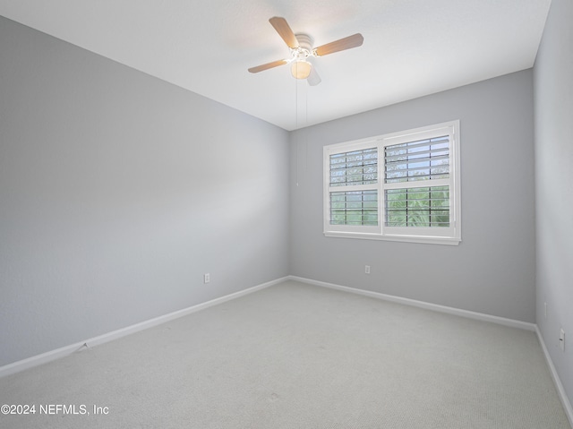 carpeted spare room featuring ceiling fan