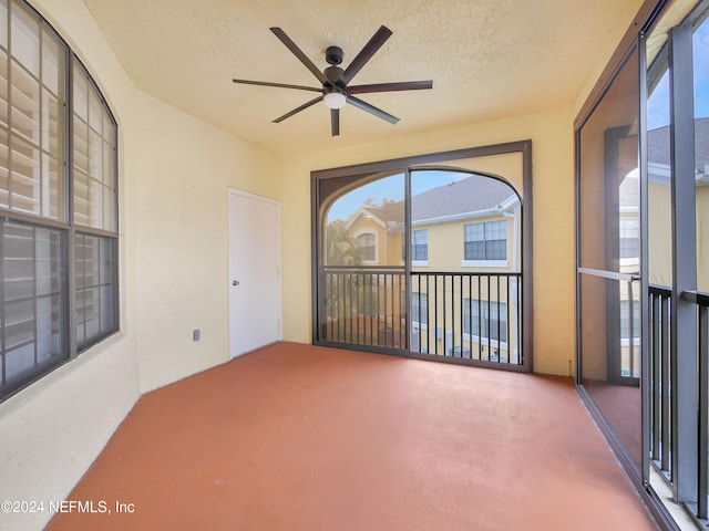 unfurnished sunroom featuring a wealth of natural light and ceiling fan