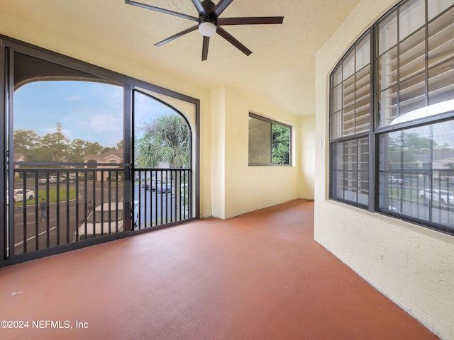 unfurnished sunroom with ceiling fan