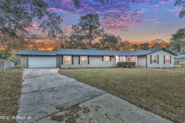 ranch-style house with a garage and a lawn