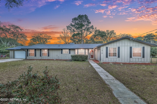 ranch-style house with a yard and a garage