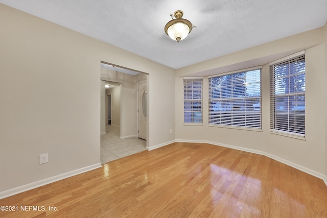 empty room featuring a textured ceiling and light wood-type flooring