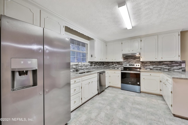 kitchen featuring light stone countertops, backsplash, stainless steel appliances, sink, and white cabinets