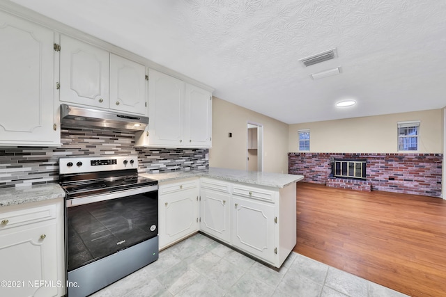 kitchen with light wood-type flooring, white cabinets, electric stove, and kitchen peninsula