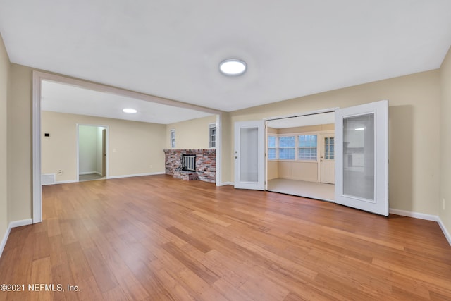 unfurnished living room with a wood stove and light hardwood / wood-style floors