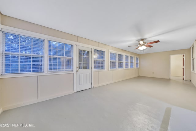 unfurnished sunroom with ceiling fan