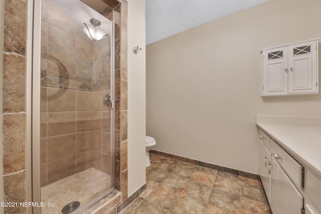 bathroom featuring walk in shower, toilet, and vanity