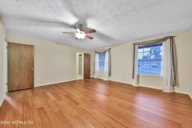 unfurnished room with light wood-type flooring, a textured ceiling, and ceiling fan