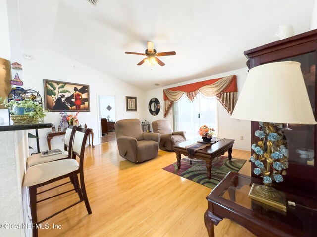 living room featuring wood-type flooring, lofted ceiling, and ceiling fan