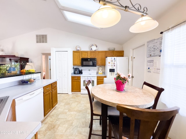 kitchen with lofted ceiling, white appliances, and pendant lighting