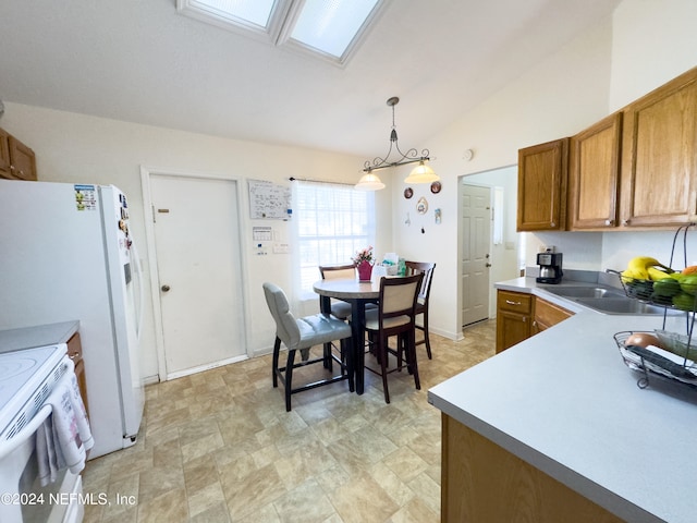 kitchen with lofted ceiling with skylight, decorative light fixtures, sink, and white appliances