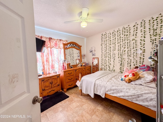 bedroom with ceiling fan and a textured ceiling