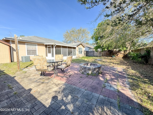 view of patio featuring a sunroom, an outdoor fire pit, and central air condition unit