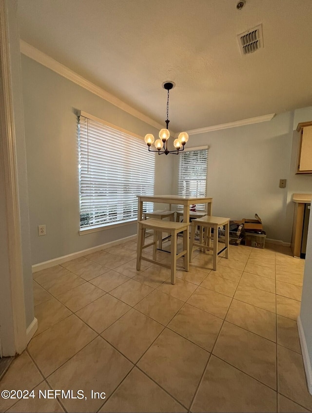 dining area with light tile patterned floors, crown molding, and a notable chandelier