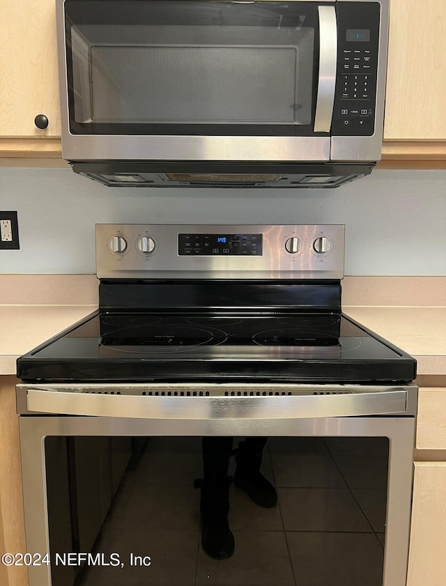 room details featuring stainless steel appliances and light brown cabinets