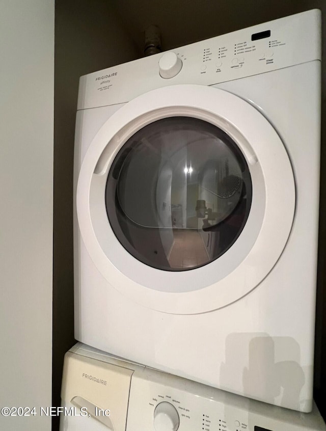 washroom featuring stacked washer and clothes dryer