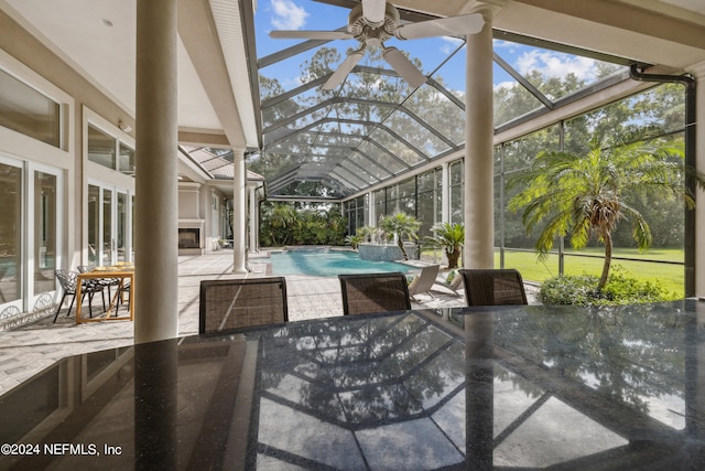 view of patio / terrace with ceiling fan and a lanai