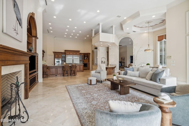 living room with a towering ceiling and crown molding