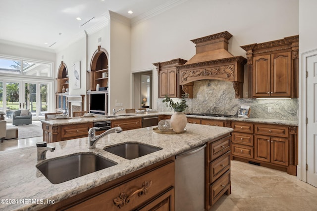 kitchen with sink, crown molding, appliances with stainless steel finishes, and light stone counters