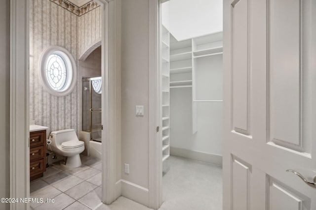 full bathroom with vanity, shower / bath combination with glass door, toilet, and tile patterned floors