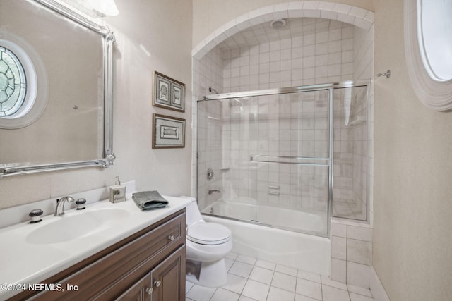 full bathroom with vanity, combined bath / shower with glass door, toilet, and tile patterned flooring