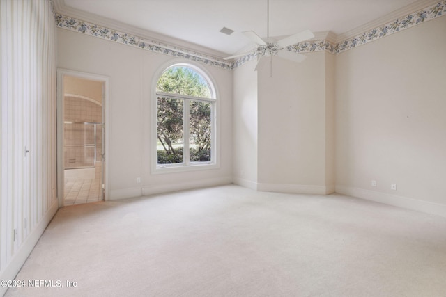 empty room featuring ornamental molding, light colored carpet, and ceiling fan