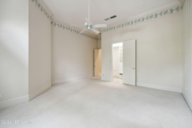 carpeted empty room featuring crown molding and ceiling fan