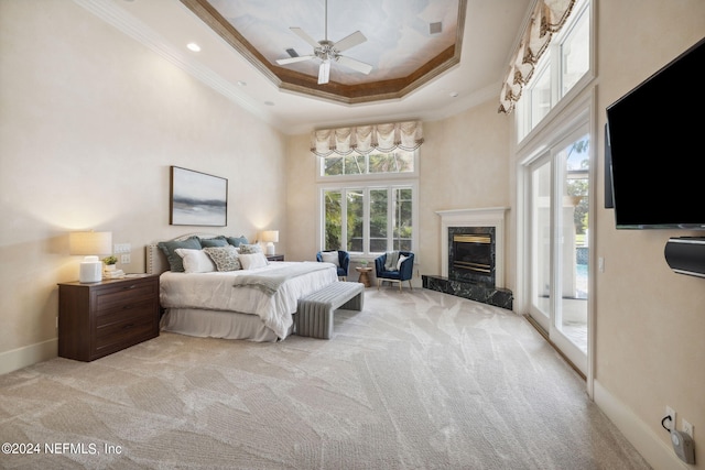 bedroom featuring a premium fireplace, access to exterior, light colored carpet, and ceiling fan